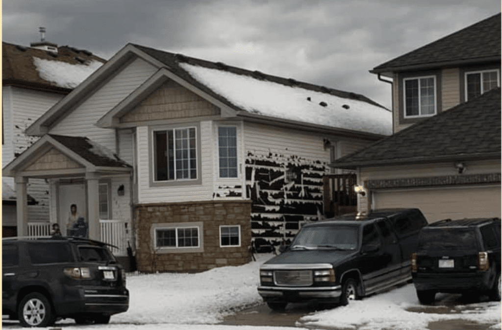 Hail damage caused to the siding of house during Calgary storm.
