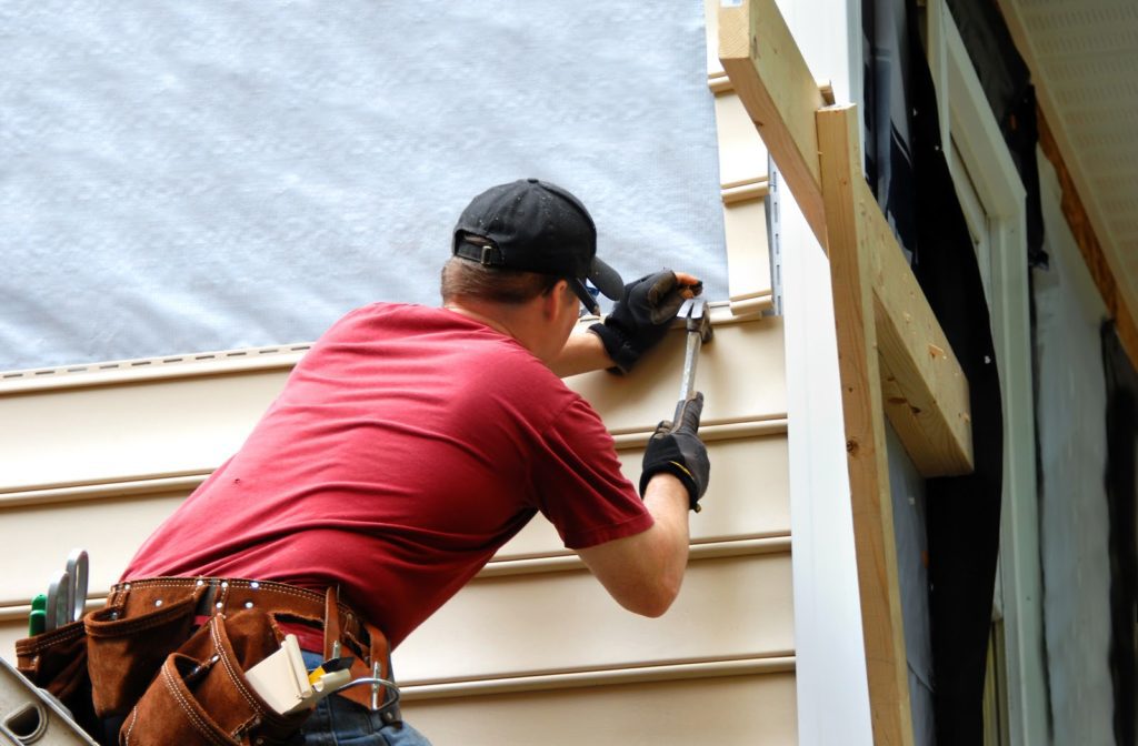 Young professional installing house siding