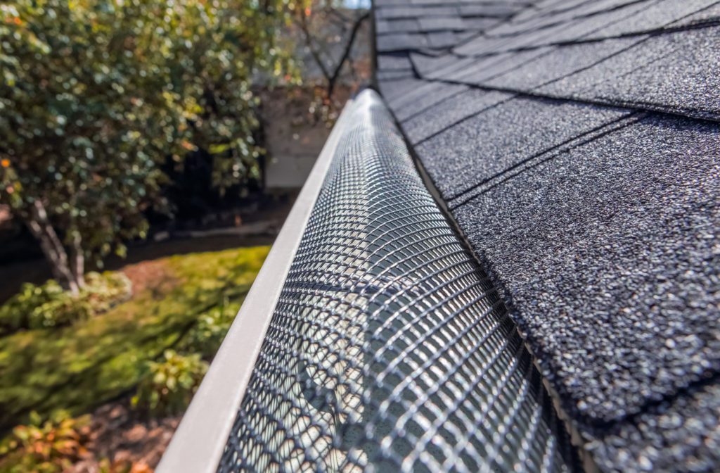 Plastic guard over gutter on a roof to keep it free of leaves