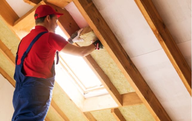 Professional putting in insulation into attic area