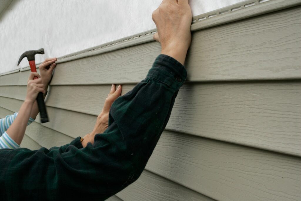 Workers installing siding on a house