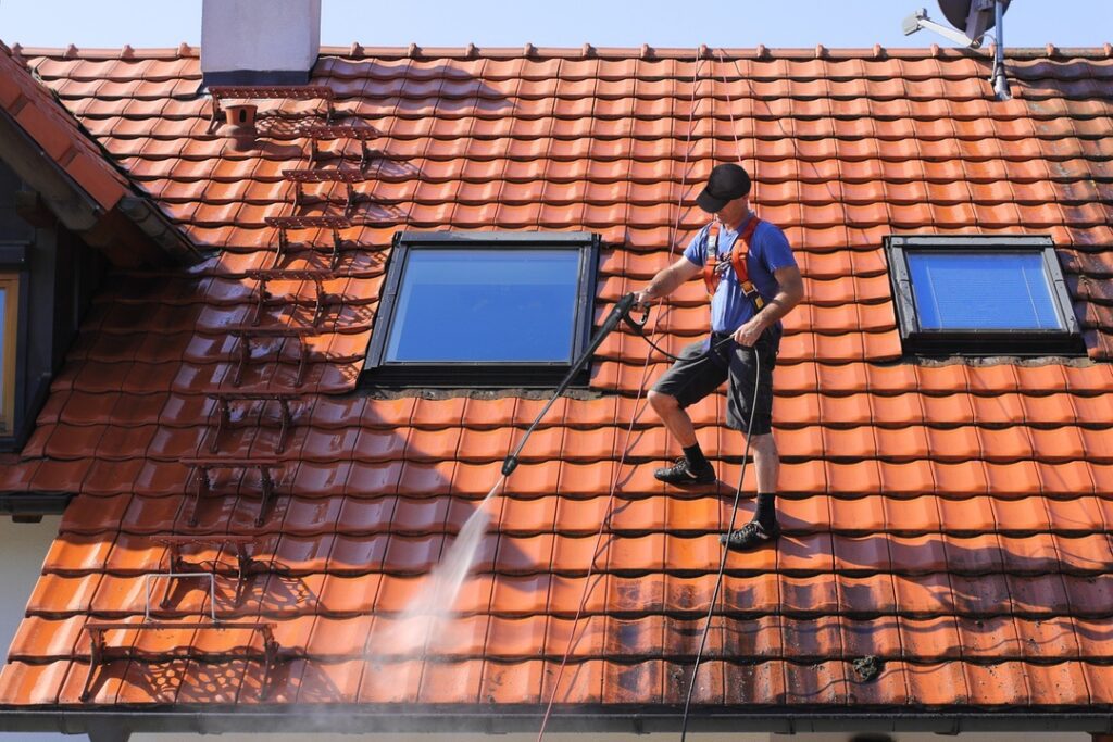 Man on roof demonstrating unnecessary skylight cleaning technique