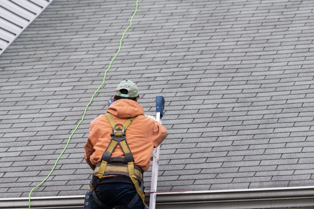 Roofing contractor accessing rooftop to perform repairs