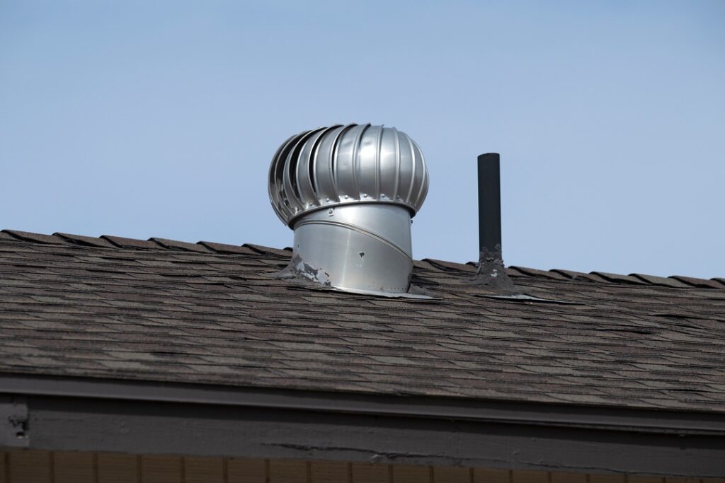 Damaged roof vent on roof with asphalt shingles