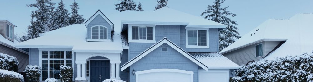 Blue house with snow on the roof, and ground.
